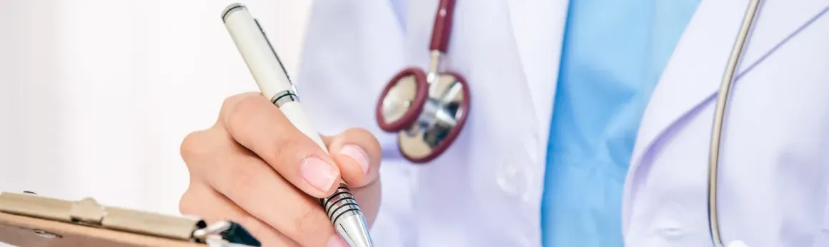 Doctor writing on clipboard